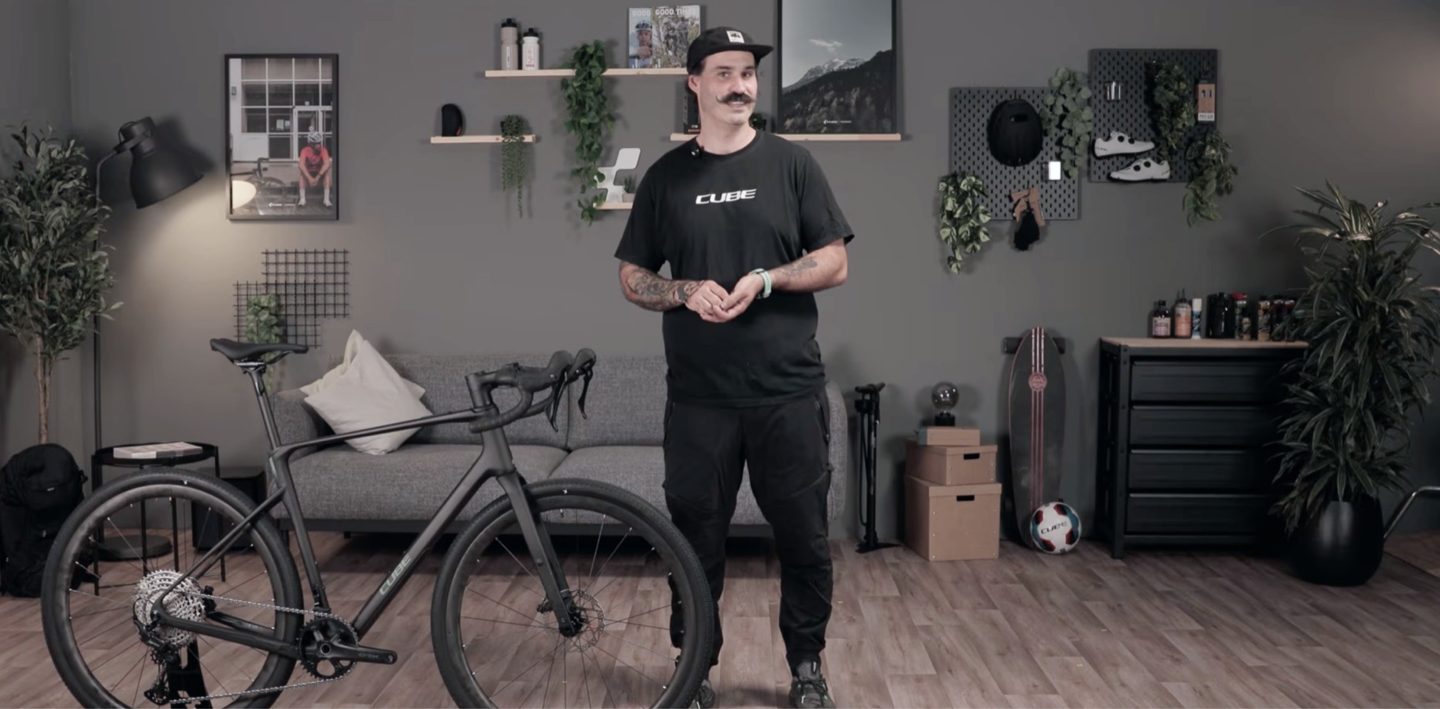 Bene steht neben dem Cube Nuroad C:62 ONE 2027 und zeigt den Carbonrahmen